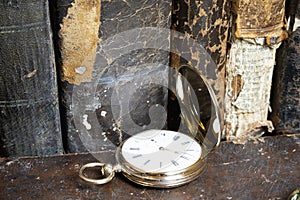 Gold pocket watch Pavel Bure on a gold pendant. Royal Russia. pocket watch on a dark background with books.