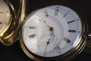 Gold pocket watch Pavel Bure on a gold pendant. Royal Russia. pocket watch on a dark background with books.