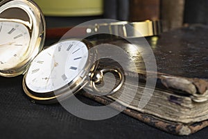 Gold pocket watch Pavel Bure on a gold pendant. Royal Russia. pocket watch on a dark background with books.