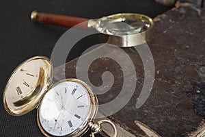 Gold pocket watch Pavel Bure on a gold pendant. Royal Russia. pocket watch on a dark background with books.