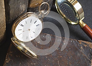 Gold pocket watch Pavel Bure on a gold pendant. Royal Russia. pocket watch on a dark background with books.