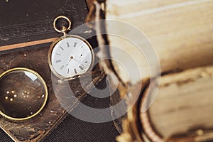 Gold pocket watch Pavel Bure on a gold pendant. Royal Russia. pocket watch on a dark background with books.