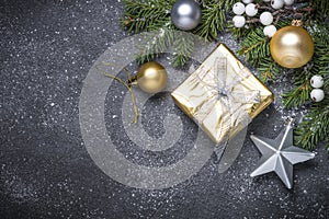 Gold present box and decorations on black stone background.