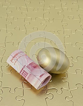 Gold puzzle with Chinese money and nest egg