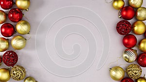 Gold and red shiny Christmas ornaments appear on left and right side of silver theme. Stop motion