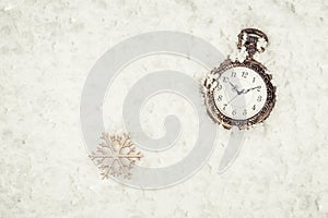 Gold Retro pocket watch and wooden snowflake on snow. Christmas and New Year concept
