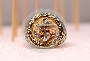 Gold ring in anchor shape in close up in white background