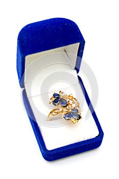 Gold ring with blue sapphires and cubic zirkonia in gift box on white background
