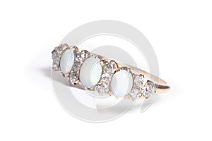 Gold ring with diamonds and opals, on a white background