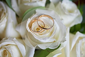 gold rings and a beautiful bridal bouquet of roses on the background. details  wedding traditions. close-up  macro
