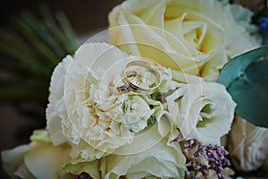 gold rings and a beautiful bridal bouquet of roses on the background. details  wedding traditions. close-up  macro