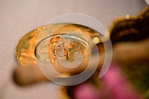 Gold rings lie on a gold plate in the church, the wedding process.