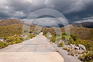 The gold`s road, San Luis, Argentina, which climbs steppe mountains. Seen from below while a heavy storm is coming