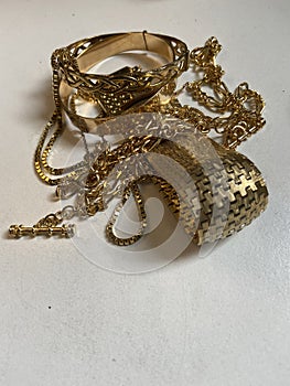 Gold scrap pile chains and bangle jewelry on scale