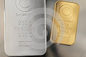 Gold and silver bars on an abstract gray