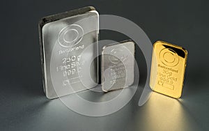 Gold and silver bars of different weight on a dark