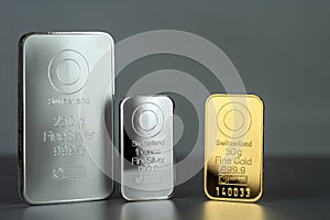 Gold and silver bars of different weight on a gray