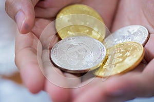 Gold and silver Bitcoins holding in hand, virtual manry and cryptocurrency concept