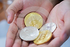 Gold and silver Bitcoins holding in hand, virtual manry and cryptocurrency concept