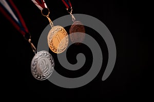 Gold, silver and bronze medals with numbers on black isolated background for winners