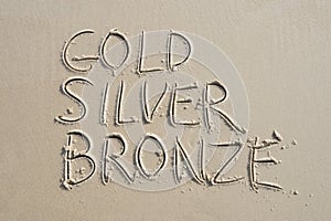 Gold Silver Bronze Message on Smooth Sand