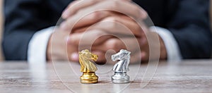 Gold and silver Chess Knight horse figure with businessman manager background. Strategy, Conflict, management, business planning