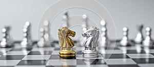 Gold and silver Chess Knight horse figure on Chessboard against opponent or enemy. Strategy, Conflict, management, business