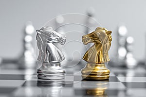 Gold and silver Chess Knight horse figure on Chessboard against opponent or enemy. Strategy, Conflict, management, business