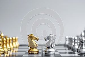 Gold and silver Chess Knight horse figure on Chessboard against opponent or enemy. Strategy, Conflict, management, business