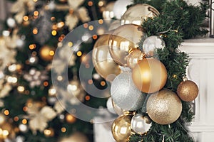 Gold and silver Christmas toys, balls garlands on a spruce branch