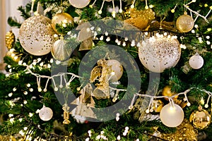 Gold and silver Christmas toys, balls and garlands on a spruce branch on christmas tree