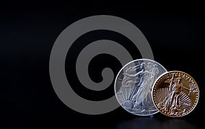 A gold and silver coin in corner of a black backdrop