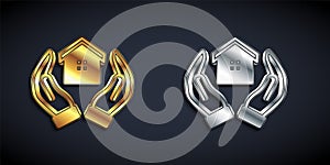 Gold and silver House in hand icon isolated on black background. Insurance concept. Security, safety, protection