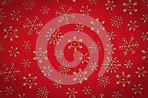 Gold snowflakes on red material holiday background photo