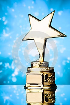 Gold star award trophy against blue background