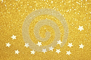 Gold star confetti glitter background. Shiny holiday golden decoration. Defocused bokeh lights