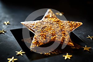 gold star-patterned cracker on a shiny glass surface