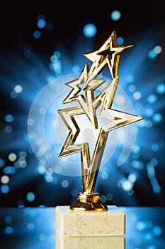 Gold stars trophy against shiny background