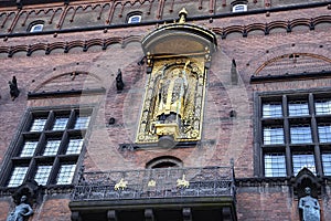 Gold statue of archbishop and statesman Absalon on facade of City Hall building in Copenhagen, Denmark. February 2020