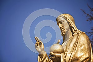 Gold statue Jesus Christ. He holds the sphere with a cross as a symbol of the trusteeship of Christianity above the earth