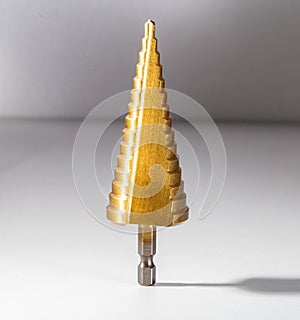 Gold step drill for drilling holes of different diameters, close-up. Professional