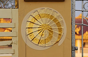 Gold stucco circle on the fence, symbolic of Dharma wheel