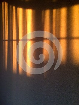 Gold sunlight streams through curtains for golden design background