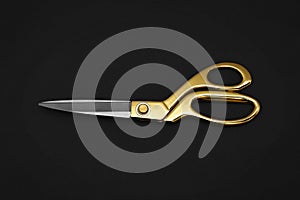 Gold tailor scissors on black background