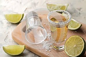 Gold tequila in a glass shot glass with salt and lime on a light concrete background. bar. alcoholic beverages