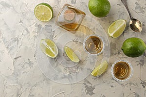 Gold tequila in a glass shot glass with salt and lime on a light concrete background. bar. alcoholic beverages. view from above. w