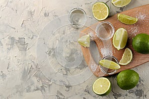 Gold tequila in a glass shot glass with salt and lime on a light concrete background. bar. alcoholic beverages. view from above. w