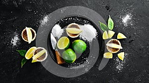 Gold tequila with lime and salt on black stone background. Top view.