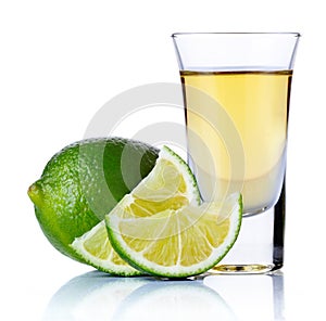 Gold tequila shot with lime isolated on white