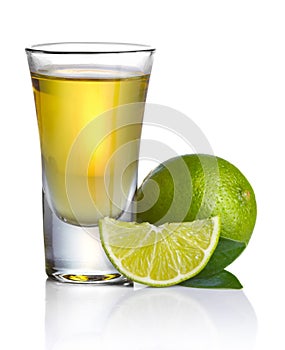 Gold tequila shot with lime isolated on white